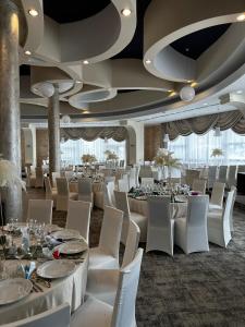 代日Black Tulip Hotel的宴会厅配有白色的桌子和白色的椅子