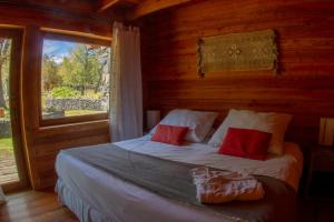 拉斯特朗卡斯Rocanegra Mountain Lodge的木制客房的一张床位,设有窗户
