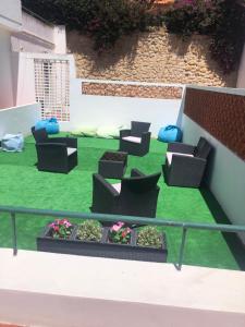拉戈斯Pensão Dona Ana - Residencial的阳台配有椅子和绿色草坪。