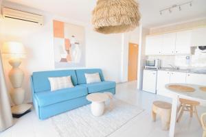 圣安东尼奥湾伊维萨岛日落绿洲公寓-只限成人的一间带蓝色沙发的客厅和一间厨房