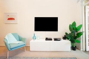 悉尼Bayside Tranquility的客厅配有电视和蓝椅