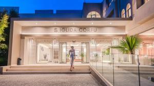达西亚Iolida Corfu Resort & Spa by Smile Hotels的站在商店橱窗前的人