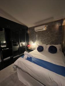 Kampong Bari KechilBERUNTUNG KE BARI RESORT @ PANTAI PENARIK的卧室配有带蓝色枕头的大型白色床