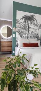 克莱蒙费朗Maison cosy terrasse ensoleillé的一间卧室配有一张带镜子和棕榈树的床