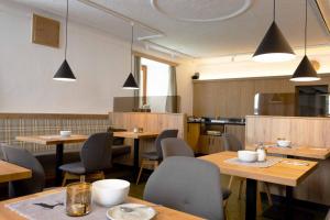 锡尔茨贾尼络温酒店的餐厅设有木桌和椅子及灯