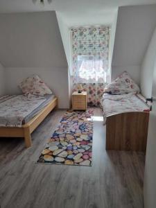 大梅灵Gasthaus Weigl的小房间设有两张床和地毯