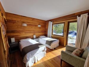 拉斯特朗卡斯Rocanegra Mountain Lodge的一间卧室设有两张床、一张沙发和一个窗口