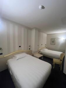维亚雷焦伦敦酒店的酒店客房,配有两张床和椅子