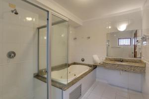 阿瓜斯迪林多亚弗雷迪酒店的带浴缸和玻璃淋浴间的浴室。