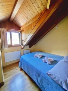 索特Apartaments Sort Pirineus的阁楼卧室配有蓝色床