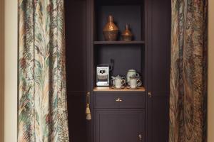 马盖特No 42 by GuestHouse, Margate的一间设有架子的客房,上面配有咖啡壶
