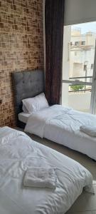 卡萨布兰卡Appartement 2 chambres hay hassani的带窗户的客房内的两张床