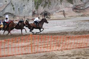 扎马亚Itzurun, Zumaia, te encantara!的一群骑马的人在赛道上骑