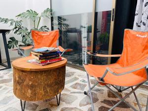 麦德林Casa compartida ''Central Hostel''的两张橙色椅子和一张桌子,上面有书籍