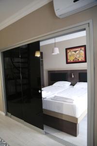 埃杰阿巴德Maidos suites的卧室设有玻璃门,可通往一张床