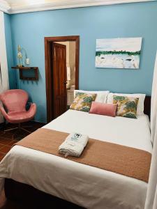 蒙波斯Casa Isabelita的一间卧室配有一张床和一张粉红色的椅子