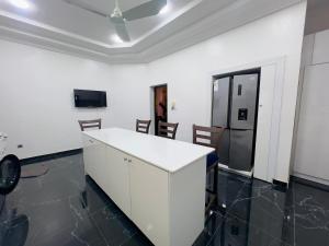 科托努Luxe Club的厨房配有白色的柜台和冰箱。