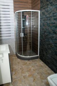 科托努La pépite的浴室里设有玻璃门淋浴