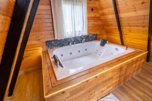 KumlucaKaraöz Sapphire Bungalows的木墙客房内的大浴缸