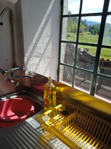 洛萨Casa Pintarolas的厨房水槽,窗户旁设有碗碟干燥架