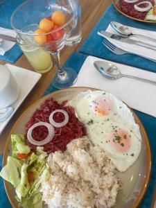 BugallonRiver Palm Hotel and Resort powered by Cocotel的桌上一盘带鸡蛋和米饭的食物