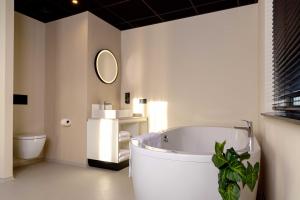 戈伊斯Hotel Waterstate的一间带大浴缸和卫生间的浴室