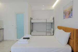 卡萨米尔Vila Sofia的卧室配有带白色床单的双层床