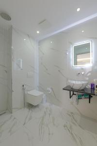 卡萨米尔Vila Sofia的白色的浴室设有水槽和卫生间。