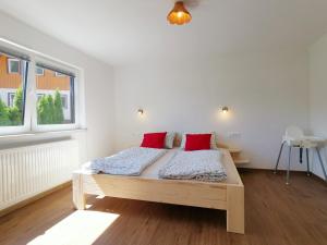 波希基斯卡贝拉Apartma pr´ Štengarju的一间卧室配有一张带两个红色枕头的木床