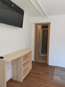 波希基斯卡贝拉Apartma pr´ Štengarju的客房设有一张桌子,墙上配有电视