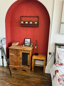 伯明翰Premium Dighbeth的一间设有红色墙壁、桌子和书架的房间