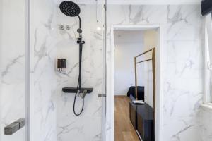 里斯本Lisbon 5 Hotel的带淋浴的浴室,拥有白色的大理石墙壁