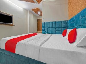 贾姆谢德布尔All Seasons Corporate的一间卧室配有一张带红色和蓝色枕头的大床