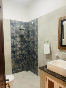 卡图纳耶克Lucky Transit Hotel的一间带水槽、卫生间和镜子的浴室