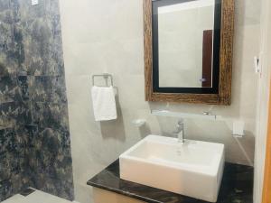 卡图纳耶克Lucky Transit Hotel的浴室设有白色水槽和镜子