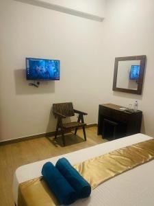 卡图纳耶克Lucky Transit Hotel的一间卧室配有一张床、一把椅子和镜子