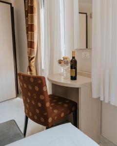 斯特雷萨弗洛拉酒店的一间带椅子和一瓶葡萄酒的房间