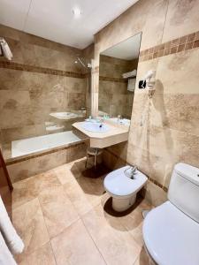 马拉加马拉加卡洛斯五世酒店的浴室配有卫生间、盥洗盆和浴缸。