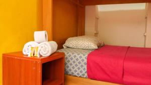 利马Sumaq Wasi Barranco II的一间卧室配有一张床铺和一张桌子上的毛巾