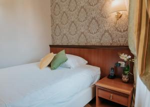 斯特雷萨弗洛拉酒店的卧室配有白色的床和带电话的床头柜。