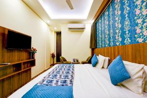 新德里Wood Rose Hotel Near Delhi Airport的一间酒店客房,配有一张床和一台电视