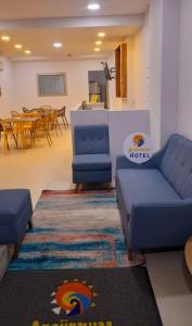 里奥阿查ANAJIRAWAA HOTEL的一间设有两张蓝色沙发和一张桌子的等候室