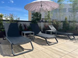 格拉纳达Apartamentos Luna Suites Granada的庭院里摆放着一对椅子和一把遮阳伞