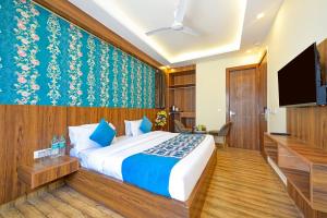 新德里Wood Rose Hotel Near Delhi Airport的一间卧室配有一张床和一台平面电视