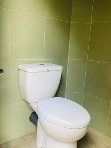 蒂瑟默哈拉默Yala Village Eco Tree House的浴室铺有绿色瓷砖,设有白色卫生间。