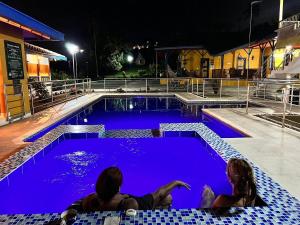 佩雷拉Ecohotel Guaduales Pereira的两人晚上坐在游泳池里