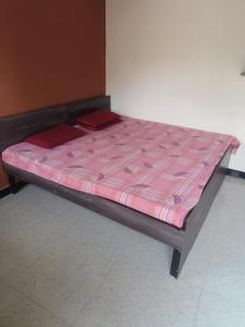 乌贾因Kailash kuti Guest House的一张位于带粉红色床垫的房间内的床铺