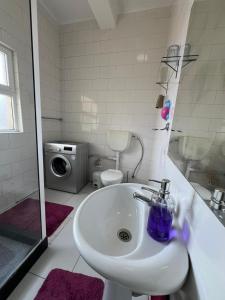 卢班戈J´S Place的一间带水槽和洗衣机的浴室