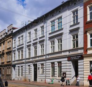 克拉科夫Starowiślna VIP Apartamenty JACUZZI的街道边的白色建筑