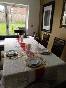 普雷斯科特House Rose 1的餐桌,上面有盘子和玻璃杯